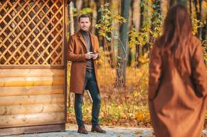 glückliche Familie, die an einem sonnigen Herbsttag im Herbstpark spazieren geht foto