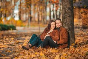 glückliche Familie, die an einem sonnigen Herbsttag im Herbstpark spazieren geht foto