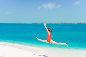 tolles kleines mädchen am strand, das im sommerurlaub viel spaß hat foto