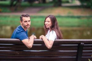 Entspannte junge Familie auf der Bank im Park foto