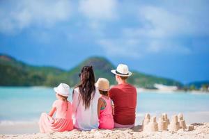 Vierköpfige Familie, die Sandburgen am Strand von Tropica baut foto