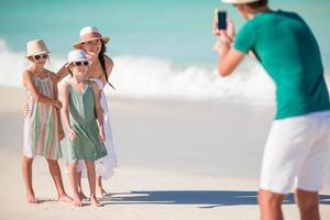 Eine vierköpfige Familie, die in ihrem Strandurlaub ein Selfie-Foto macht. foto