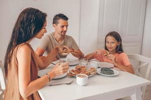 glückliche familie, die zusammen in der küche frühstückt foto