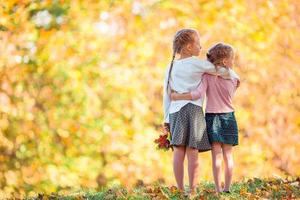 Kleine entzückende Mädchen im Freien am warmen, sonnigen Herbsttag foto