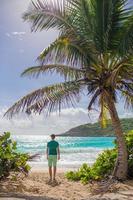 junger Mann, der Sommerferien am tropischen Strand genießt foto
