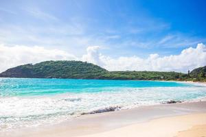 idyllischer tropischer strand in der karibik mit weißem sand, türkisfarbenem ozeanwasser und blauem himmel foto