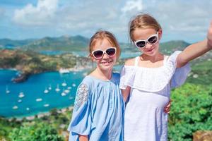 Entzückende kleine Kinder, die den Blick auf den malerischen englischen Hafen von Antigua in der Karibik genießen foto