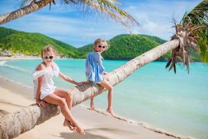 Entzückendes kleines Kind, das sich während der Sommerferien am Strand amüsiert foto