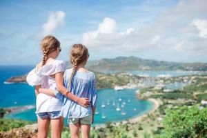 Entzückende kleine Kinder, die den Blick auf den malerischen englischen Hafen von Antigua in der Karibik genießen foto