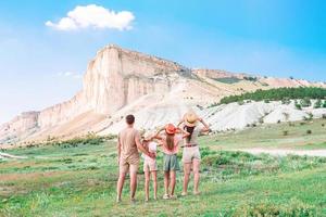 glückliche vierköpfige Familie beim Wandern in den Bergen foto