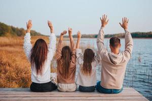 Schöne Familie am warmen Herbsttag in der Nähe des Sees foto