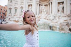 entzückender hintergrund des kleinen mädchens trevi-brunnen, rom, italien. foto