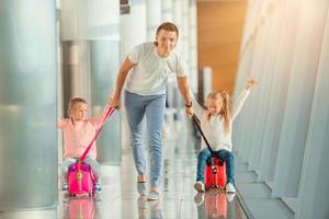 glückliche familie mit zwei kindern am flughafen viel spaß beim warten auf das einsteigen foto