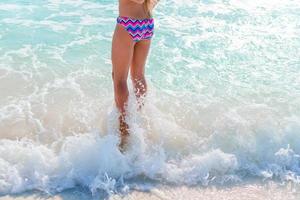 entzückendes kleines mädchen hat spaß am tropischen strand während des urlaubs foto