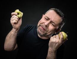 Mann mittleren Alters mit grünen Äpfeln foto