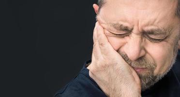 Kopfschmerzen. Mann mit Gesicht von Hand geschlossen foto