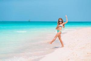 entzückendes kleines Mädchen am Strand in ihren Sommerferien foto