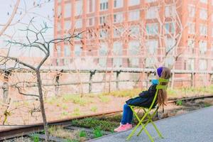 entzückendes kleines mädchen genießt den sonnigen tag auf der high line von new york foto