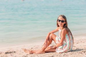 entzückendes kleines mädchen hat spaß am tropischen strand während des urlaubs foto