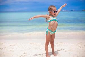 entzückendes kleines Mädchen am Strand während der Sommerferien foto