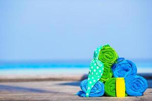 Strand- und Sommerurlaubszubehör-Konzept - Nahaufnahme von bunten Handtüchern, Schwimmbrillen und Sonnencreme foto