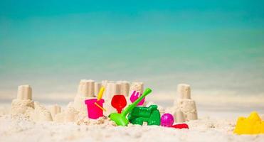 Sandburg am weißen Strand mit Plastikspielzeug für Kinder foto