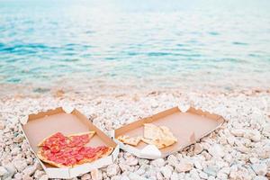 frische pizza auf dem strandhintergrund des meeres foto