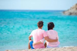 junge zweiköpfige Familie am weißen Strand während der Sommerferien foto