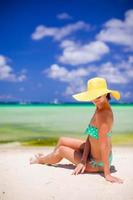 schöne Frau im gelben Hut am weißen tropischen Strand foto