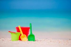 Strandspielzeug für Kinder auf weißem Sand. Eimer und Klingen für Kinder am weißen Sandstrand nach Kinderspielen foto