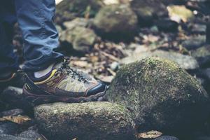 Nahaufnahme der Füße eines Mannes, die auf einem Bergweg wandern foto