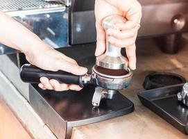 Barista drückt den Espresso-Boden nieder foto