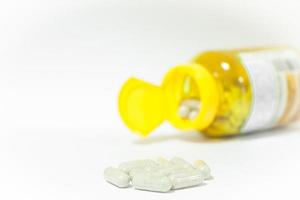 Nahaufnahme von Pillen mit einer gelben Flasche foto