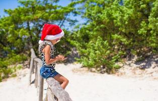 süßes schönes kleines mädchen in weihnachtsmütze während der vavation foto