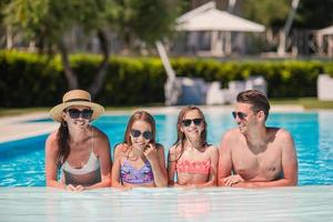 glückliche vierköpfige Familie im Schwimmbad foto