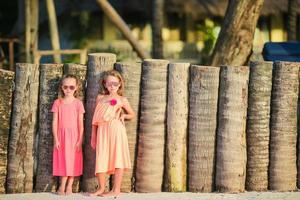 entzückende kleine Mädchen am weißen Strand. glückliche Schwestern foto