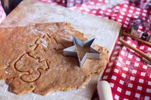 Schneiden des Lebkuchenplätzchenteigs für Weihnachten und Neujahr foto