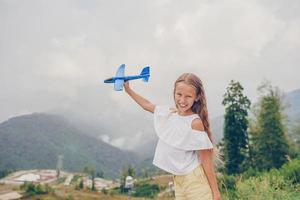 schönes glückliches kleines Mädchen in den Bergen im Hintergrund des Nebels foto