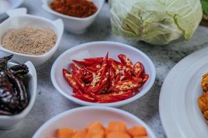 Karottenwürfel, getrocknete Chilis, gerösteter Reis, Chili und Kohl foto