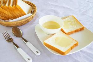 Brot und gesüßte Kondensmilch auf einem Teller foto