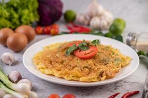 Omelett auf einem weißen Teller mit Tomaten und Koriander foto