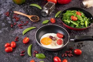 Spiegeleier in einer Pfanne mit Tomaten foto