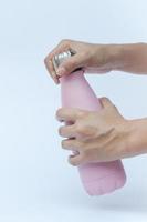 Nahaufnahme einer Person, die eine rosa Wasserflasche öffnet