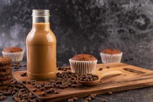 Kaffee in der Flasche mit Kaffeebohnen und Muffins foto
