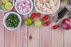 gekochte Hühnchenstücke mit Gemüse und Gewürzen auf einem Holztisch foto