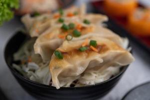 Gyoza in einer schwarzen Tasse foto