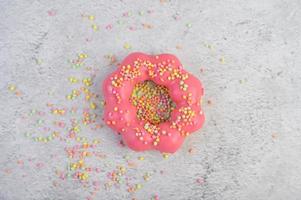 Erdbeer Donut mit Zuckerguss und Streuseln dekoriert foto