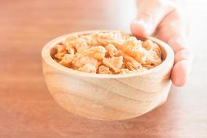 Hand hält eine Holzschale mit gebratenen Garnelen foto