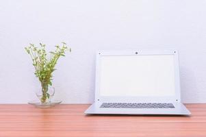 Laptop und Blume auf dem Schreibtisch foto