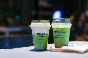 Eistee Matcha Grüntee Latte auf Tisch im Laden. foto